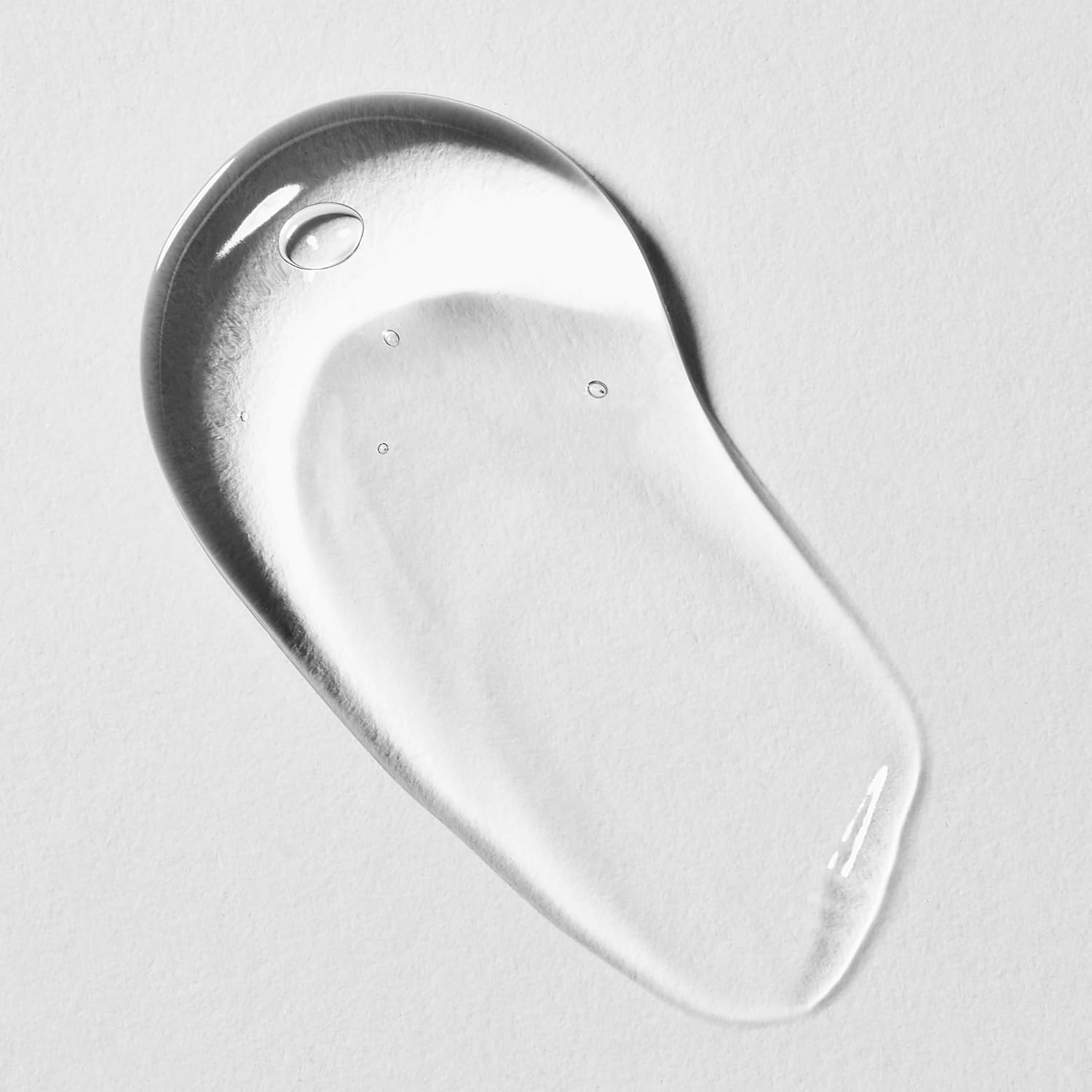 Clear liquid droplet on a light gray background